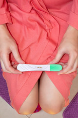A woman holds a pregnancy test in her hands, closeup.