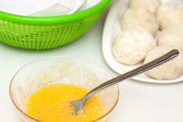 Preparation steps of traditional Colombian dish called stuffed potatoes: Dunking stuffed potatoes in egg and flour mixture