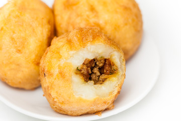 Preparation steps of traditional Colombian dish called stuffed potatoes : Ready stuffed potatoes served in a white ceramic dish isolated on white background