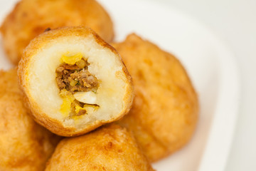 Preparation steps of traditional Colombian dish called stuffed potatoes : Ready stuffed potatoes served in a white ceramic dish isolated on white background