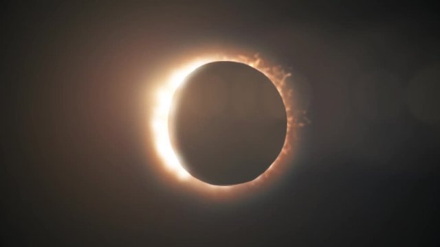 Abstract full solar eclipse on scientific black background. The Moon mostly covers the visible Sun creating a golden diamond ring effect.