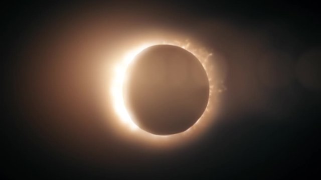 Abstract full solar eclipse on scientific black background. The Moon mostly covers the visible Sun creating a golden diamond ring effect.