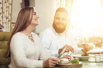 Happy man and woman have lunch in a restaurant