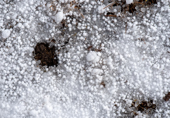 Hail and snow on frozen ground
