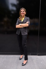 Full length portrait of happy mature businesswoman outdoors