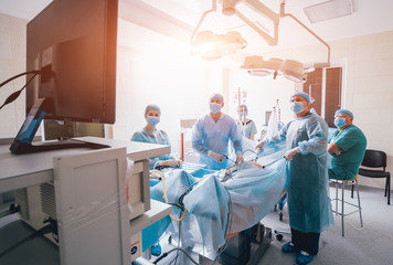 Process of gynecological surgery operation using laparoscopic equipment. Group of surgeons in...