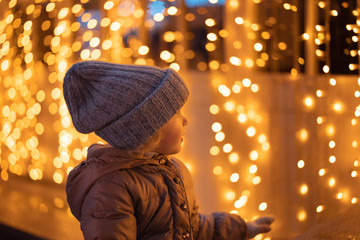 portrait of happy girl in winter evenings on background of Christmas lights
