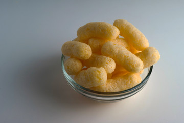 Corn Puffs in a Glass Bowl. Crunchy Flavored Puffed Snacks. Party, Movie Snacks.