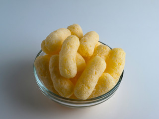 Corn Puffs in a Glass Bowl. Crunchy Flavored Puffed Snacks. Party, Movie Snacks.