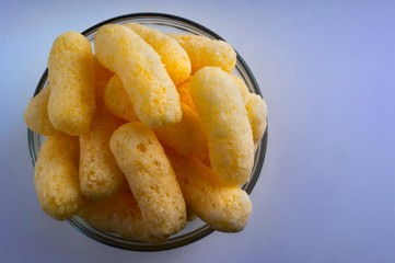 Corn Puffs in a Glass Bowl. Crunchy Flavored Puffed Snacks. Party, Movie Snacks.
