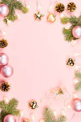 Fototapeta na wymiar Christmas background with fir branches, lights, pink decorations on pink