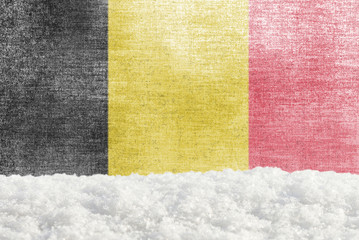 Fototapeta premium Winter grunge background with snowdrift and Belgian flag in the backdrop