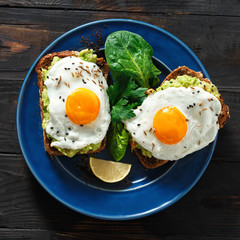 Top view healthy avocado toasts fried egg cheerful faces Healthy breakfast table