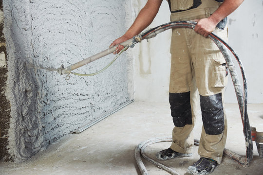 plastering the interior wall with an automatic spraying plaster pump machine