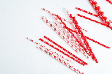 Drinking straws for party on white background. Top view of colorful paper straws for cocktails. Place for text, copy space.