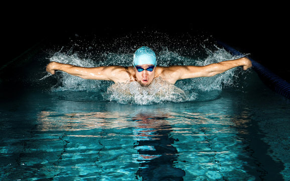 Man in swimming pool. Butterfly swimming style