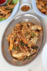 Deep fried mantis shrimp with garlic in a stainless steel  plate on the table. Selective focus.