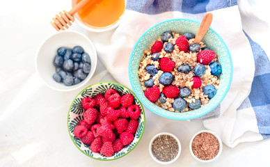 High protein healthy breakfast, buckwheat porridge with blueberries, raspberries, flax seeds and honey Closeup view, selective focus