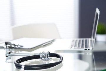 Stethoscope, prescription medical form lying on glass table with laptop computer. Medicine or pharmacy concept. Medical tools at doctor working table