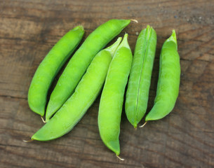 View of fresh ripe green peas lying on a rustic table. Peas in a pod close-up, organic food.