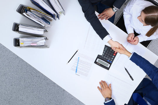 Business People Shaking Hands At Meeting, View From Above. Bookkeeper Or Financial Inspector  Making Report, Calculating Or Checking Balance