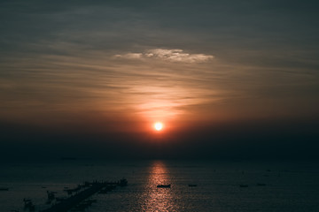 Fototapeta premium Sunset at the bridge by the sea with a boat surrounded.