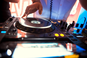 Fototapeta na wymiar Dj playing the track in the nightclub at a party
