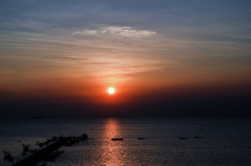 Sunset at the bridge by the sea with a boat surrounded.