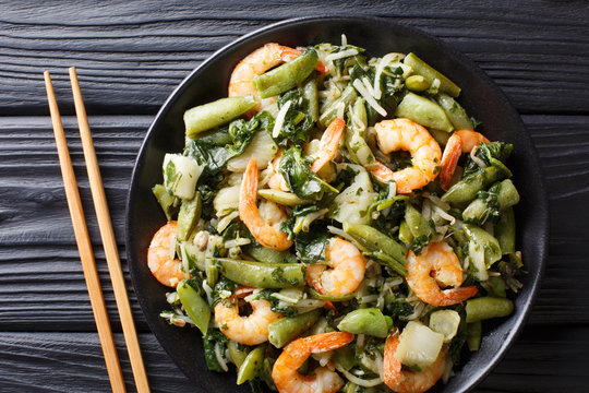 Chinese traditional Stir frying of shrimp, spinach, soy sprouts, pea pods and pak choi close-up on a plate. horizontal top view