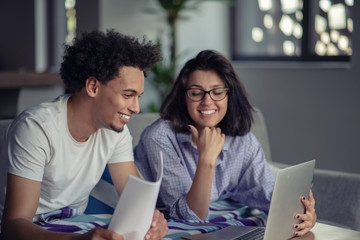 Worried young couple discussing bills at home