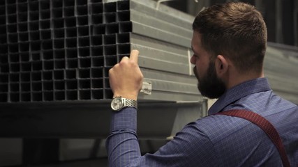 A man with a beard chooses building materials in a hardware store.