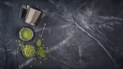 Top view of raw green unroasted ground beans with geyser coffee maker and silver spoon
