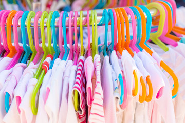 Rack of baby and children used dress, clothes displayed at outdoor hanger market for sale.