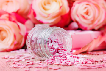 Pink sugar hearts, Valentines card on background of fresh roses, selective focus