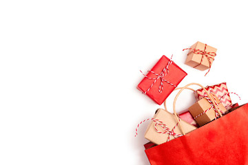 Red shopping bag with gifts on a white background and copy space.