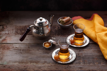 Traditional turkish teapot and cups of tea on woden background