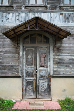 Door with shoe symbol ans small roof in an old wooden house