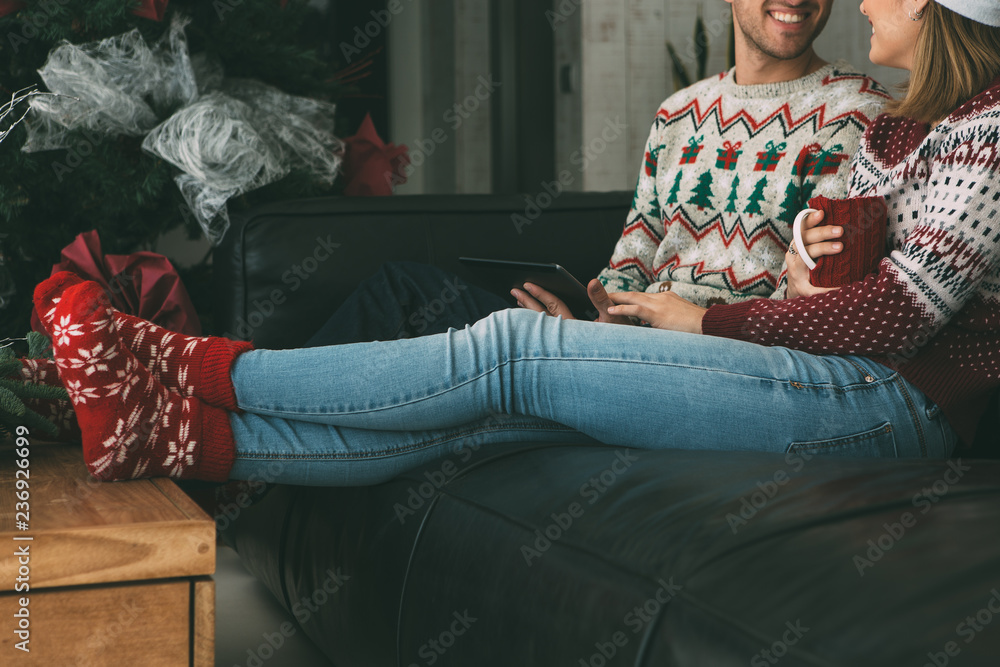 Wall mural Young woman and man enjoying Christmas time at home