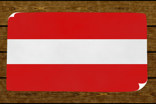 Illustration of an Austrian flag on the paper pasted on the woody wall