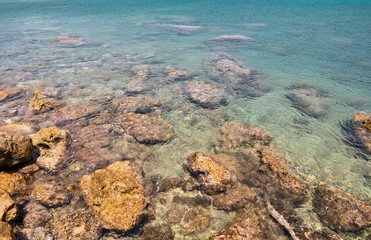 Fototapeta na wymiar Stones In Shallow Turquoise Sea