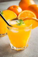 Photo of fresh orange juice in the glass jar. Summer healthy organic drink concept. Cold beverages with ice and orange fruits.