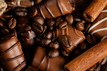 Assortment of white, dark, and milk chocolate. Chocolate with cream, nuts, almonds, hazelnuts and cinnamon with coffee beans. Sweet food and no diet concept.