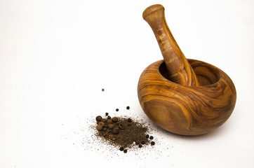 wooden mortar for grinding different spices on light background