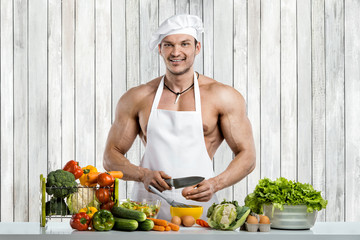 Man bodybuilder cooking on kitchen