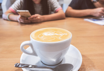 Hot coffee latte on a wooden table.