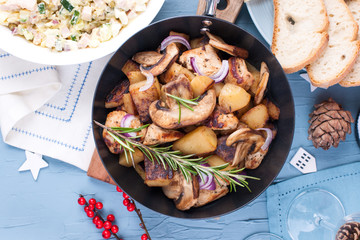 Different traditional food for the New Year's table. Russian salad, fried potatoes with mushrooms. Top view. Free space for copy of text.