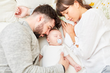 Eltern schlafen neben ihrem kleinen Baby - obrazy, fototapety, plakaty