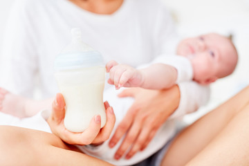 Mutter hält Fläschchen mit Babymilch