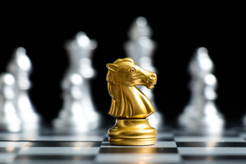 Gold knight chess piece face with silver team on black background (Concept for company strategy,...