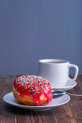 fresh delicious  donut and a cup of black tea for breakfast